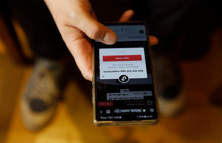 Έφηβος μπαίνει στο TikTok από το κινητό του (φωτ.: EPA / Luong Thai Linh)