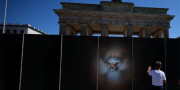 Επισκέπτης παρατηρεί την κυψελοειδή εγκατάσταση για τα 65 χρόνια από την ανέγερση του Τείχους του Βερολίνου. Το έργο, μήκους 30 και ύψους τριών μέτρων, έχει στηθεί μπροστά από την Πύλη του Βρανδεμβούργου (φωτ.: EPA / Hannibal Hanschke)