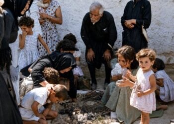 Η στιγμή που τα παιδιά του αγωνιστή της ΕΟΚΑ Ανδρέα Παναγίδη αντικρίζουν για πρώτη φορά τον τάφο του πατέρα τους (πηγή: Ιστορικές Μνήμες ΕΟΚΑ 1955-59/Εικόνα επεξεργασμένη με Τεχνητή Νοημοσύνη)