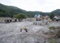 Παιδιά περπατούν ανάμεσα σε κτήρια που υπέστησαν ζημιές από πλημμύρα παγετώνα κοντά στα σύνορα Νεπάλ-Κίνας, η οποία στοίχισε τη ζωή σε εκατοντάδες ανθρώπους, στο Τρισούλι Μπαζάρ του Νουβακότ στο Νεπάλ (φωτ.: EPA/SURYAMS UPRETI AUSTRALIA AND NEW ZEALAND OUT)