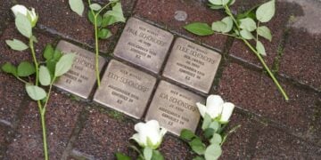 Λευκά τριαντάφυλλα σε «Stolpersteine» (λιθόστρωτα μνήμης), στο Ντόρστεν της Γερμανίας (φωτ. αρχείου: EPA/ Christopher Neundorf)