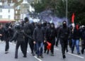 Κουκουλοφόροι διαδηλωτές στον σιδηροδρομικό σταθμό Dover Priory, καθώς αποχωρούν από το Ντόβερ μετά τον πολύωρο αποκλεισμό των οδών προς το λιμάνι. Σάββατο 5 Σεπτεμβρίου 2026 (φωτ.: Oscar Rihll / PA Wire / DPA / Picture Alliance)