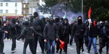 Κουκουλοφόροι διαδηλωτές στον σιδηροδρομικό σταθμό Dover Priory, καθώς αποχωρούν από το Ντόβερ μετά τον πολύωρο αποκλεισμό των οδών προς το λιμάνι. Σάββατο 5 Σεπτεμβρίου 2026 (φωτ.: Oscar Rihll / PA Wire / DPA / Picture Alliance)