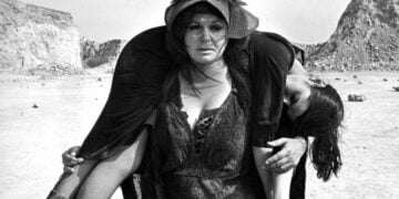 Σκηνή από την ταινία «1922», του Νίκου Κούνδουρου. Η Μπέτυ Βαλάση κουβαλά στους ώμους την Ελεονώρα Σταθοπούλου (πηγή: Ταινιοθήκη της Ελλάδος - Μουσείο Κινηματογράφου)