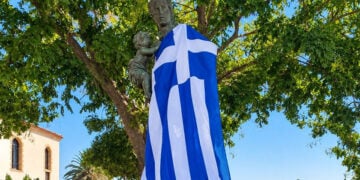 Το Μνημείο της Μικρασιάτισσας Μάνας στη Νέα Κούταλη, καλυμμένο με την ελληνική σημαία μετά την επιμνημόσυνη δέηση και την κατάθεση στεφάνων (φωτ.: Facebook / Κοινότητα Νέας Κούταλης Λήμνου)