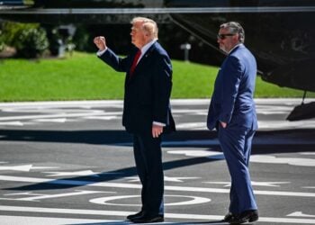Ο Αμερικανός πρόεδρος Ντόναλντ Τραμπ (αριστερά) χαιρετά με υψωμένη τη γροθιά το πλήθος πίσω από το σχοινί ασφαλείας, κατά την αναχώρησή του από τον Λευκό Οίκο στην Ουάσινγκτον (φωτ.:  EPA/ANNABELLE GORDON / POOL)