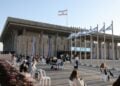Άνθρωποι κάθονται έξω από το ισραηλινό Κοινοβούλιο, την Κνέσετ, στην Ιερουσαλήμ (φωτ.: EPA/ABIR SULTAN EPA)