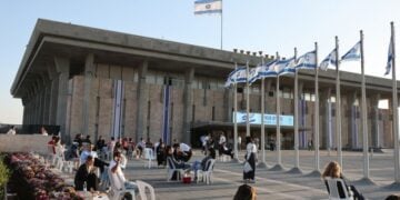 Άνθρωποι κάθονται έξω από το ισραηλινό Κοινοβούλιο, την Κνέσετ, στην Ιερουσαλήμ (φωτ.: EPA/ABIR SULTAN EPA)