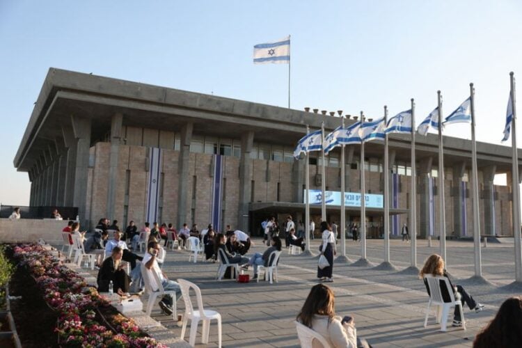 Άνθρωποι κάθονται έξω από το ισραηλινό Κοινοβούλιο, την Κνέσετ, στην Ιερουσαλήμ (φωτ.: EPA/ABIR SULTAN EPA)