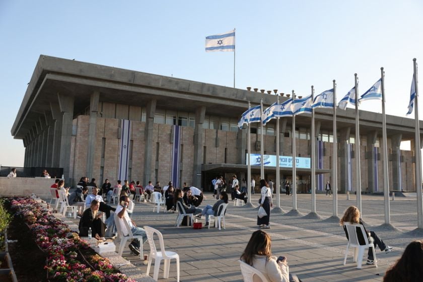 Άνθρωποι κάθονται έξω από το ισραηλινό Κοινοβούλιο, την Κνέσετ, στην Ιερουσαλήμ (φωτ.: EPA/ABIR SULTAN EPA)