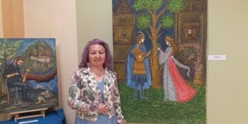 Η εικαστικός και ιστορικός Σοφία Αμπερίδου ανάμεσα σε έργα της από την ατομική έκθεση «Ανθεί και φέρει» που εντάσσεται στις εκδηλώσεις για τα 160 χρόνια από την Αρκαδική Εθελοθυσία στο Ρέθυμνο της Κρήτης (φωτ.: Αρχείο Σοφίας Αμπερίδου)
