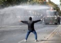 Διαδηλωτής με πέτρες στα χέρια απέναντι από «Αύρα», κατά τη διάρκεια φοιτητικής διαδήλωσης στα Τίρανα, στις 15 Οκτωβρίου 2026 (φωτ.: EPA / Malton Dibra)