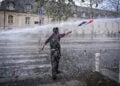 Διαδηλωτής απέναντι σε «Αύρα» κατά τη διάρκεια μαθητικής και συνδικαλιστικής κινητοποίησης στο Παρίσι, για τις συνθήκες στα σχολεία. 13 Οκτωβρίου 2026 (φωτ.: EPA / Firas Abdullah)