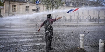 Διαδηλωτής απέναντι σε «Αύρα» κατά τη διάρκεια μαθητικής και συνδικαλιστικής κινητοποίησης στο Παρίσι, για τις συνθήκες στα σχολεία. 13 Οκτωβρίου 2026 (φωτ.: EPA / Firas Abdullah)