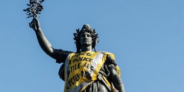 Το άγαλμα της Δημοκρατίας με κίτρινο γιλέκο, μετά τις συγκρούσεις αστυνομικών και διαδηλωτών στις κινητοποιήσεις κατά της ακρίβειας στο Παρίσι, στις 18 Οκτωβρίου 2026 (φωτ.: EPA / Mohammed Badra)