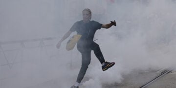 Μαθητής λυκείου κλωτσά κάνιστρο δακρυγόνου κατά τη διάρκεια συγκρούσεων με αστυνομικές δυνάμεις, σε διαδήλωση για τις συνθήκες στην εκπαίδευση στο Μονπελιέ της νότιας Γαλλίας, στις 2 Οκτωβρίου 2026 (φωτ.: EPA / Guillaume Horcajuelo)