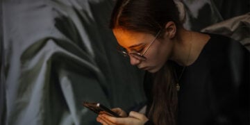 Νεαρή ηθοποιός κλεισμένη σε κουτί κούκλας στην καλλιτεχνική και ακτιβιστική εγκατάσταση «Kid Tok Shop» της Διεθνούς Αμνηστίας Γαλλίας, στην πλατεία της Όπερας στο Παρίσι, στις 25 Νοεμβρίου 2025. Η δράση είχε στόχο την ευαισθητοποίηση για τις επιπτώσεις του TikTok στην ψυχική υγεία των νέων και την εκμετάλλευση των δεδομένων και των συναισθημάτων των χρηστών (φωτ.: EPA / Sadak Souici)
