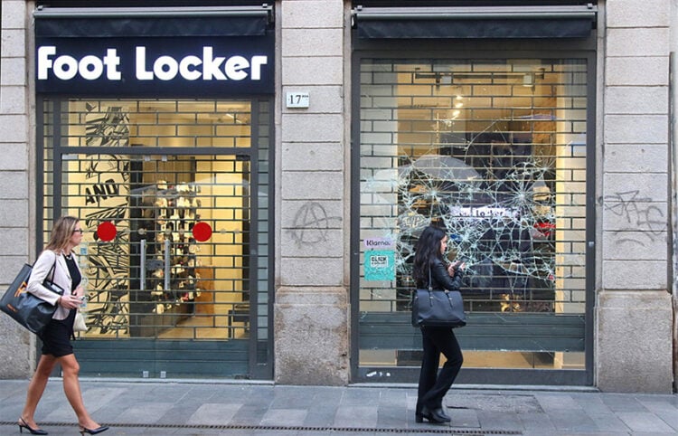 Περαστικοί μπροστά σε σπασμένη βιτρίνα καταστήματος στο Μιλάνο, στις 19 Οκτωβρίου 2026 (φωτ.: EPA / Paolo Salmoirago)