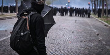 Διαδηλωτής κρατά πέτρα κατά τη διάρκεια επεισοδίων με την αστυνομία, μετά από πορεία μαθητών και συνδικάτων για τις συνθήκες στην εκπαίδευση, στο Παρίσι, στις 13 Οκτωβρίου 2026 (φωτ.: EPA / Firas Abdullah)