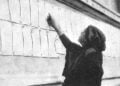 Γυναίκα εξετάζει καταλόγους με ονόματα ανθρώπων που αναζητούσαν οι συγγενείς τους, στα παλιά βασιλικά ανάκτορα της Αθήνας, όπου στεγάζονταν γραφεία της Near East Relief (φωτ.: Near East Relief Historical Society)