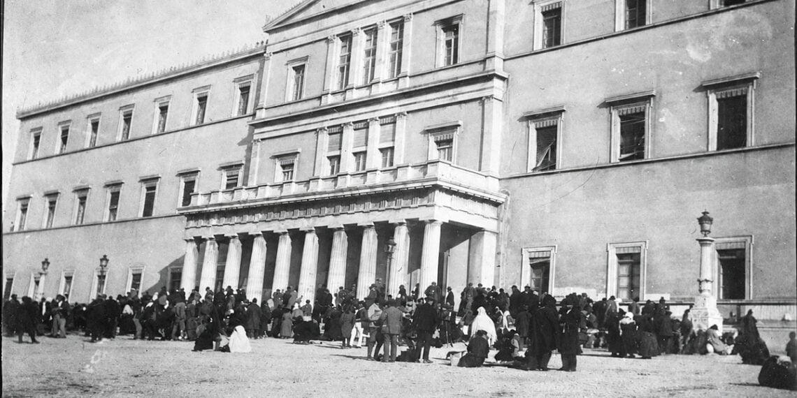 Πρόσφυγες έξω από τα παλιά ανάκτορα της Αθήνας, το 1922. Στο κτήριο λειτουργούσαν υπηρεσίες αρωγής και αναζήτησης αγνοουμένων συγγενών (φωτ.: Library of Congress / American National Red Cross)