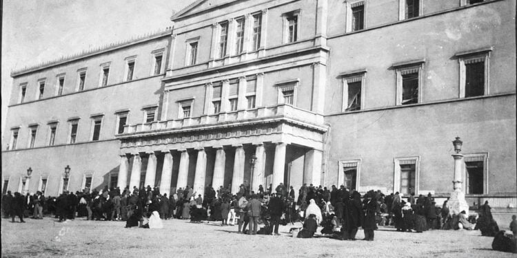 Πρόσφυγες έξω από τα παλιά ανάκτορα της Αθήνας, το 1922. Στο κτήριο λειτουργούσαν υπηρεσίες αρωγής και αναζήτησης αγνοουμένων συγγενών (φωτ.: Library of Congress / American National Red Cross)